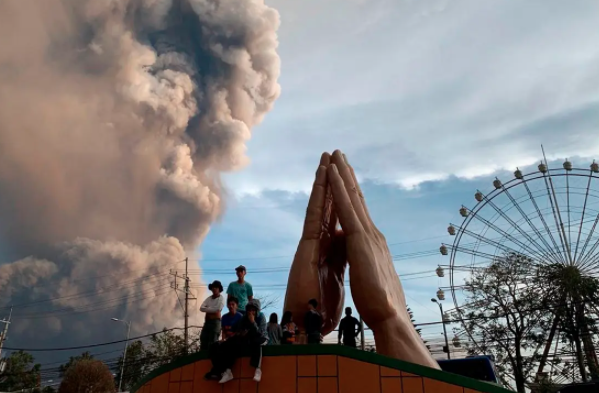 People watch as the Taal volcano spews ash and smoke during an eruption in Tagaytay, Cavite province south of Manila, Philippines on Sunday. Jan. 12, 2020. (Photo: AP)