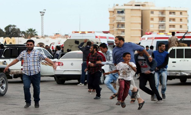 Libyan demonstrators run for cover from shelling during a protest in Benghazi calling for military forces AFP