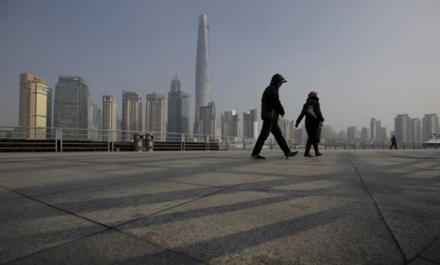 People walk in front of the financial district of Pudong in Shanghai, China, January 19, 2016. REUTERS/Aly Song