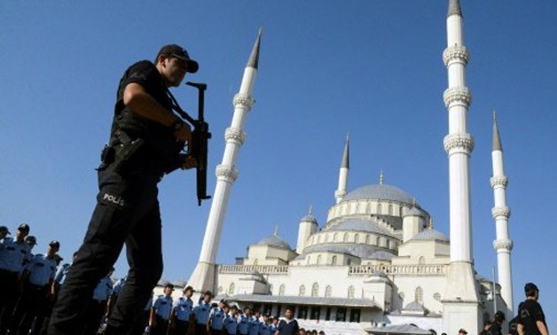 © AFP/File / by Raziye Akkoc | An armed Turkish police officer stands guard during a funeral ceremony for victims of the failed coup attempt, in Ankara on July 17, 2016