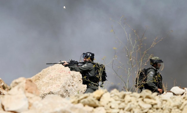 An Israeli policeman aims his weapon during clashes with Palestinians in the West Bank village of Khobar near Ramallah July 22, 2017. REUTERS/Mohamad Torokman TPX IMAGES OF THE DAY

