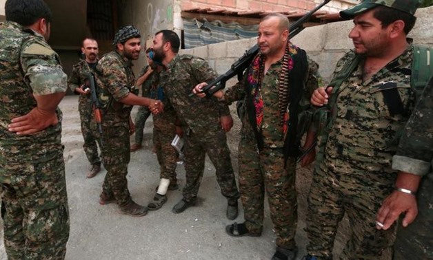 Kurdish fighters from the People's Protection Units (YPG) greet each other in the northeastern city of Hasaka, Syria, August 21, 2016 - REUTERS
