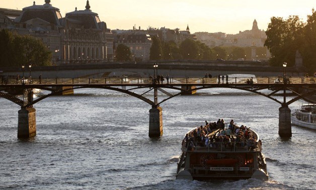 A sightseeing cruise boat goes under the Pont des Arts pedestrian bridge - AFP