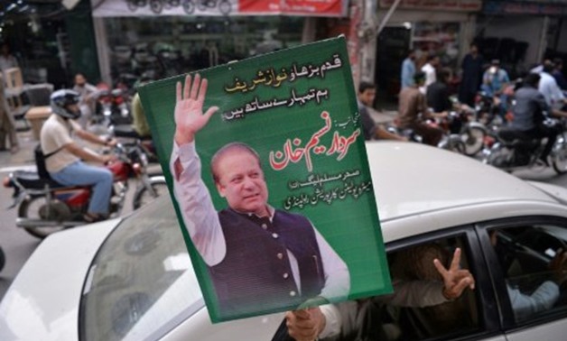 © AFP | A supporter of ousted Pakistani prime minister Nawaz Sharif carries a placard featuring his image during a rally in Rawalpindi
