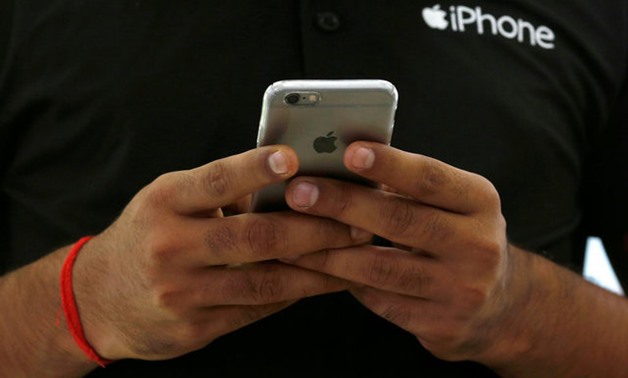 A salesman uses his iPhone at a mobile phone store in New Delhi, India, July 27, 2016. REUTERS