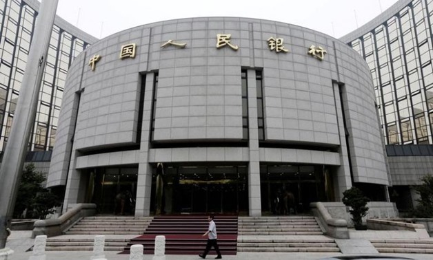  A staff member walks in front of the headquarters of the People's Bank - REUTERS