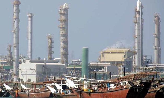 Wooden dhows are docked at a port near a Bahrain Oil Refinery Company facility.
