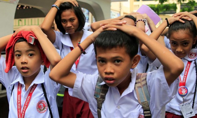 Students use their hands to cover their heads as they evacuate their school premises after an earthquake of magnitude 6.2 hit the northern island of Luzon and was felt in the Metro Manila, Philippines August 11, 2017, shaking buildings and forcing the eva