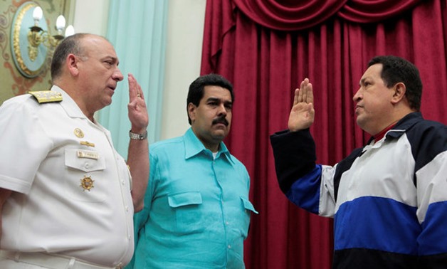 FILE PHOTO: Venezuela's President Hugo Chavez takes an oath to Admiral Diego Alfredo Molero (L) as Vice President Nicolas Maduro (C) looks on, at Miraflores Palace in Caracas, Venezuela, December 10, 2012. Miraflores Palace/Handout via REUTERS/File Photo 