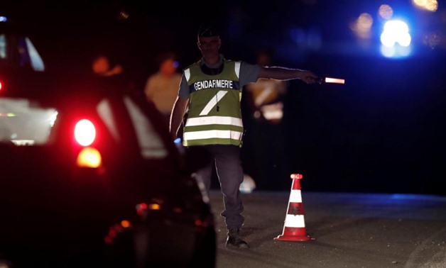 A French gendarme maintains a roadblock a certain distance from the scene where a car ploughed into the outdoor terrace of a pizzeria, killing a young girl 