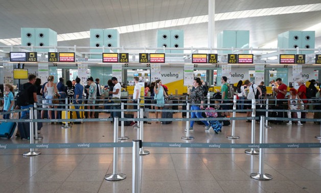 People check-in at Vueling airline desk at Barcelona-El Prat airport - REUTERS