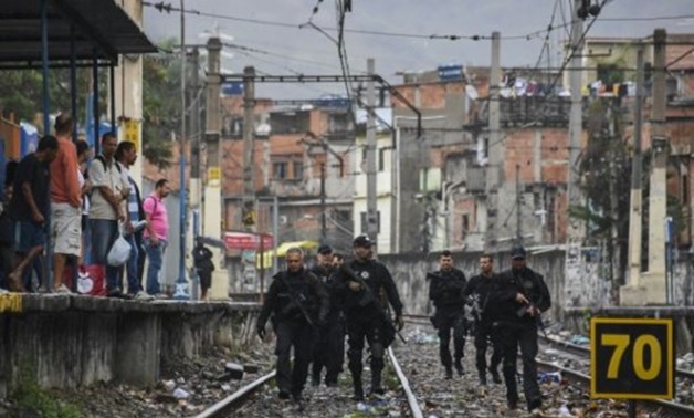 © AFP/File | Rio police, shown here carrying out a pre-dawn crackdown on drug gangs in a favela, are demoralized and struggling to contain violence