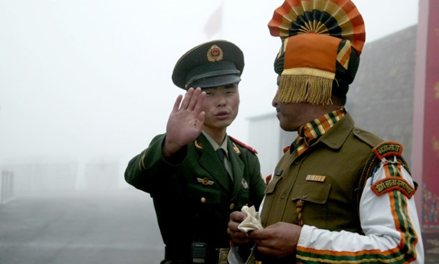 Photo taken on July 10, 2008 shows a Chinese soldier (L) gesturing next to an Indian soldier at the Nathu La border crossing between India and China in India's northeastern Sikkim state
