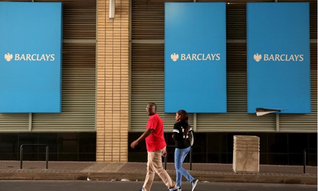 A couple walks past a Barclays logo in Johannesburg