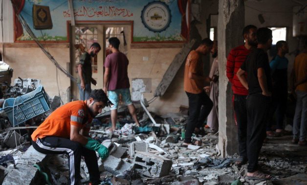 A Palestinian Red Crescent staff member sits amidst the aftermath of the Israeli airstrike at Al-Tabeen school on August 10, 2024 - Palestinian Journalists