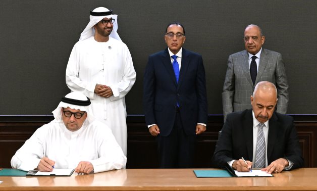 Egyptian PM Mostafa Madbouly (center), UAE’s Minister of Industry Sultan Al Jaber (L) and Egypt's Minister of Electricity Mahmoud Esmat (R) witness the signing of wind power generation plant deal - Cabinet