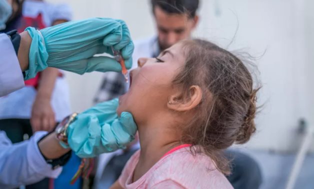 A girl receives polio drops at Badarash camp, Iraq - FILE/UNICEF