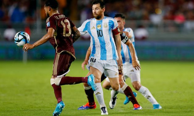 Argentina's Lionel Messi in action with Venezuela's Jose Andres Martinez REUTERS/Leonardo Fernandez Viloria