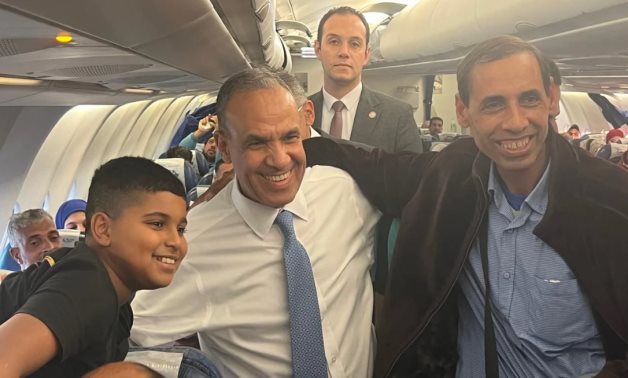 Egyptian FM poses to a picture with Egyptian nationals aboard EgyptAir flight