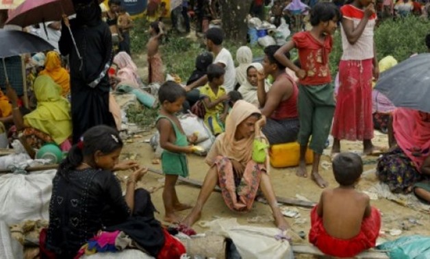 © AFP | Rohingya Muslim refugees look on after arriving from Myanmar through Lomba Beel after crossing the Naf river in the Bangladeshi town of Teknaf on September 7, 2017