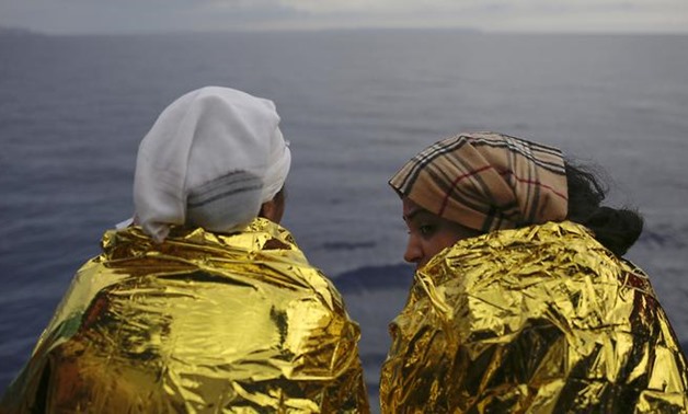 Two migrants look out on the Mediterranean Sea from the deck of a Spanish NGO vessel a day after being rescued off the Libyan coast - Photo by AP