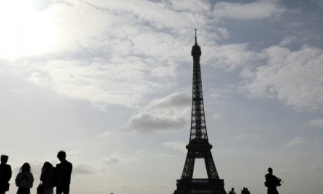 © AFP / by Marie GIFFARD | A soldier patrols near the Eiffel Tower -- a common sight in Paris since the November 2015 terror attacks