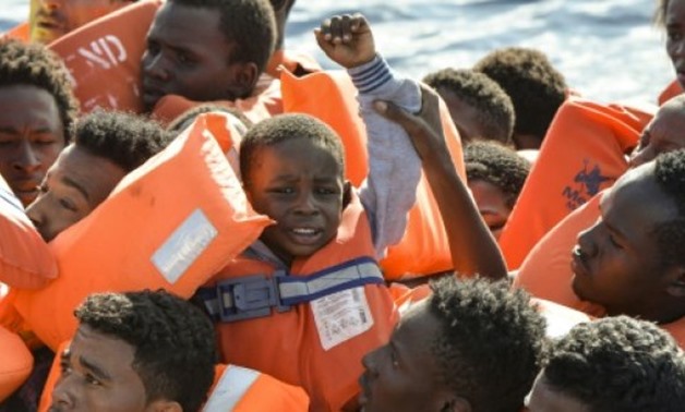 © AFP/File | A young boy is seen among the migrants and refugees seated on a rubber boat and waiting to be rescued by the Topaz Responder, a rescue ship run by Maltese NGO "Moas" and the Italian Red Cross, off the Libyan coast