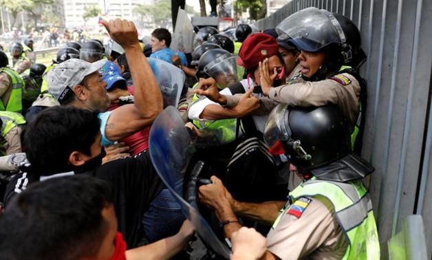 Demonstrators scuffle with security forces during an opposition rally in Caracas. REUTERS/Carlos Garcia
