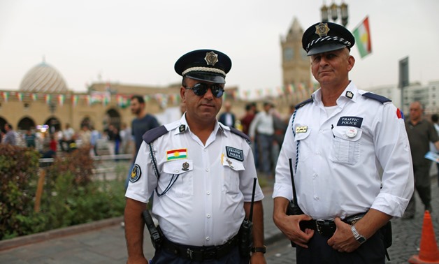 Two Kurdish traffic police officers pose for the camera in a square in the old city of Erbil, Iraq September 20, 2017. REUTERS/Ahmed Jadallah