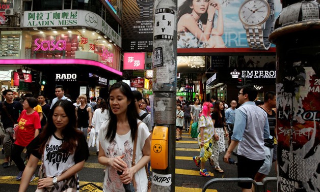 Shoppers cross a street at the Causeway Bay shopping district in Hong Kong July 22, 2014. REUTERS/Bobby Yip/Reuters
