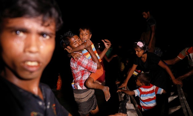 Rohingya refugees step out of a wooden boat as they arrive under the cover of darkness from Myanmar to the shore of Shah Porir Dwip, in Teknaf, near Cox's Bazar in Bangladesh - REUTERS/Damir Sagolj