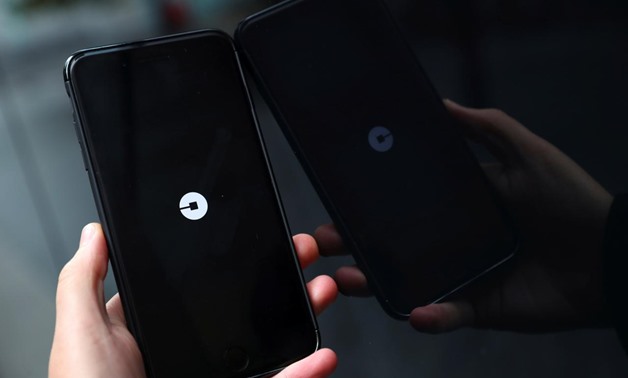 The Uber logo is seen on mobile telephone in London, Britain, September 25, 2017. REUTERS/Hannah McKay