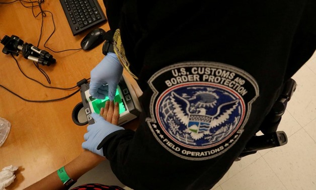 A woman who is seeking asylum has her fingerprints taken by a U.S. Customs and Border patrol officer at a pedestrian port of entry from Mexico to the United States, in McAllen, Texas, U.S., May 10, 2017. REUTERS/Carlos Barria/File Photo