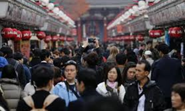 A visitor takes pictures of Nakamise shopping street on Asakusa district in Tokyo November 28, 2014. REUTERS/Yuya Shino