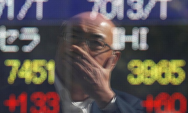 A man is reflected in an electronic stock quotation board outside a brokerage in Tokyo, Japan, October 23, 2017. REUTERS/Issei Kato