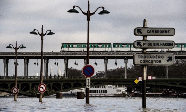 The Seine has spilled onto the streets near the Bir-Hakeim bridge in Paris, and buildings near the river say leaks are appearing in basements - AFP 
