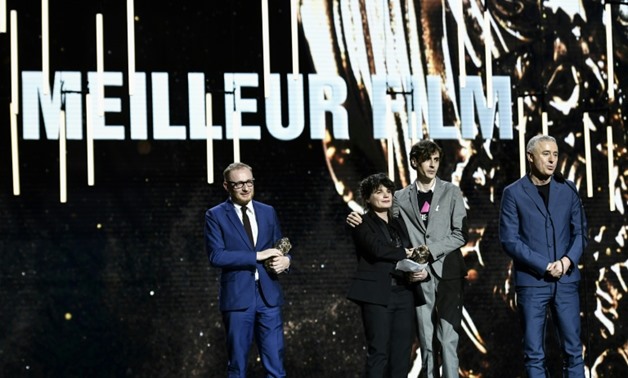 Screenwriter and director Robin Campillo (R) delivers a speech