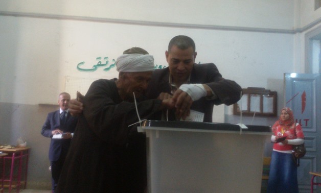 A blind elderly man is aided in casting his vote at a school in Menoufia – Egypt Today/Mahmoud Shaker