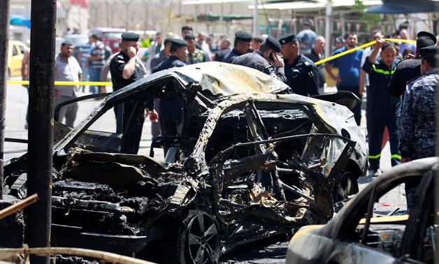 A wreckage of a car is seen at the site of car bomb attack near a government office - REUTERS/Khalid al-Mousily