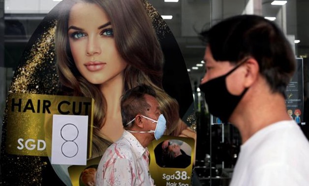 Customers queue up to have their haircut outside a hairdressing salon as they reopen for business amid the coronavirus disease (COVID-19) outbreak in Singapore May 12, 2020. REUTERS/Edgar Su
