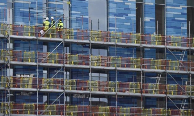 FILE PHOTO: Workers stand on scaffolding on a new building at Battersea in London, Britain, March 7, 2016. REUTERS/Toby Melville/File Photo
