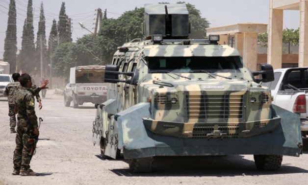 FILE PHOTO: A Syrian Democratic Forces (SDF) fighter gestures towards an armoured vehicle in Hawi Hawa village, west of Raqqa, Syria June 11, 2017. REUTERS/Rodi Said
