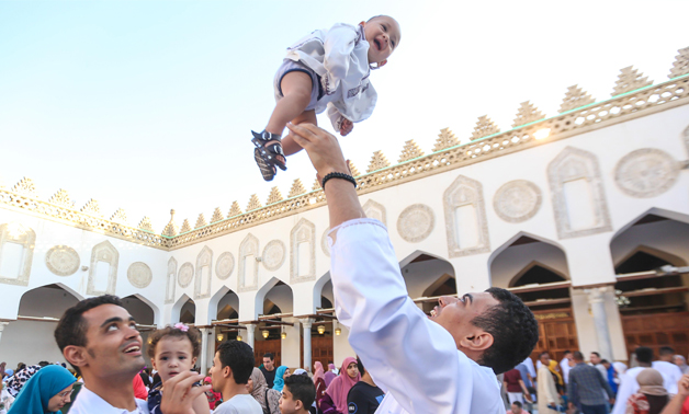 A father plays with his baby after performing Eid al-Adha prayer at Al-Azhar Mosque in Old Cairo on August 11, 2019- Egypt Today- Karim Abdel-Aziz.
